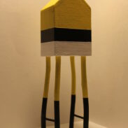 Haut de 1 mètre, cette maison miniature en bois est peinte en jaune, gris et noir
